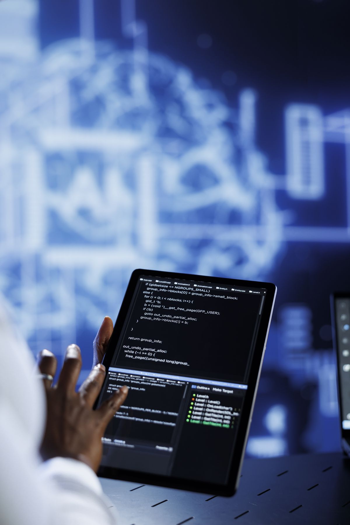 Security engineer reviewing code and systems on a tablet
